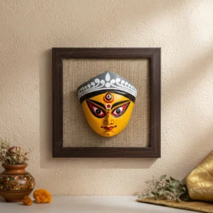 Close-up of a vibrant handmade Terracotta Durga Wall Art Hanging on a jute background, showcasing intricate details of Maa Durga's face, a prime example of Bengal crafts.