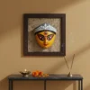 Close-up of a vibrant handmade Terracotta Durga Wall Hanging on a jute background, showcasing intricate details of Maa Durga's face, a prime example of Bengal crafts.